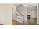 Hallway with dark hardwood floors, staircase, and a view into a living room with fireplace at 1186 Village Ne Cv, Atlanta, GA 30319