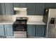 Kitchen featuring dark teal cabinets, stone countertops, and stainless steel appliances at 737 Outlook Way, Atlanta, GA 30349