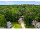 Aerial view of a charming home with a two-car garage, a long driveway, and surrounded by lush greenery at 169 Knights Ct, Dallas, GA 30157