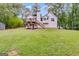 Beautiful backyard featuring a large green lawn, multi-tiered deck, and wooden staircase at 169 Knights Ct, Dallas, GA 30157