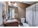 Bathroom featuring wood cabinets, double sinks and a shower-tub combo with leafy shower curtain at 169 Knights Ct, Dallas, GA 30157