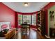 Dining room with three windows, dark wood floors, red accent wall and Coca-Cola decor at 169 Knights Ct, Dallas, GA 30157