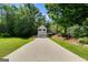 A well-maintained house with a long driveway, attached two car garage, and surrounded by green grass and trees at 169 Knights Ct, Dallas, GA 30157