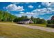 Elegant white barn with a metal roof surrounded by a sprawling green lawn and trees at 540 Benton Rd, Covington, GA 30014
