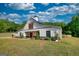 Exterior view of modern farmhouse featuring a covered porch and a well manicured lawn at 540 Benton Rd, Covington, GA 30014