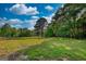 Lush green field with a charming wooden fence, surrounded by mature trees on a sunny day at 540 Benton Rd, Covington, GA 30014