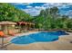 Sparkling blue pool with tanning ledge has surrounding umbrellas and an outdoor kitchen at 540 Benton Rd, Covington, GA 30014