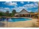 Relaxing backyard pool area has lounge chairs, waterfall, and covered outdoor dining at 540 Benton Rd, Covington, GA 30014