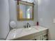 Powder room featuring marble countertops, modern fixtures, and wood-framed mirror at 540 Benton Rd, Covington, GA 30014