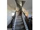Carpeted staircase with dark wooden banister leads to the upper level, showcasing the home's bright, open layout at 64 N Village Cir, Rydal, GA 30171