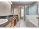Bathroom featuring dual sinks, wood cabinets, and a separate shower and tub at 3953 Willow Fields Ct, Loganville, GA 30052