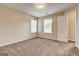 Bedroom features neutral walls, carpet, two windows, and a closet with wire shelving at 3953 Willow Fields Ct, Loganville, GA 30052