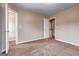 Bedroom features neutral walls, carpet, closet, and a doorway to a hallway with stairs at 3953 Willow Fields Ct, Loganville, GA 30052