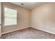 Cozy bedroom features plush carpeting, neutral walls, and a window that offers natural light at 3953 Willow Fields Ct, Loganville, GA 30052