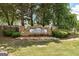 Stone sign for 'The Oaks at Fall Creek' community, surrounded by landscaping and mature trees at 3953 Willow Fields Ct, Loganville, GA 30052