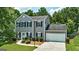 Charming two-story home featuring a manicured lawn, lush greenery, and an attached two-car garage at 3953 Willow Fields Ct, Loganville, GA 30052