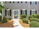 Close up of the front door framed by black shutters and manicured shrubbery at 3953 Willow Fields Ct, Loganville, GA 30052