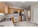 Modern kitchen with stainless steel appliances, light wood cabinets, tile floor, and white countertops at 3953 Willow Fields Ct, Loganville, GA 30052