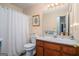 Cozy bathroom with a wooden vanity, matching framed art and a shower with white curtain at 161 Bradford Pl, Stockbridge, GA 30281
