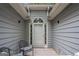 Covered front entryway with charming white door with window and decorative trim and chairs at 161 Bradford Pl, Stockbridge, GA 30281
