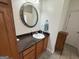 Bathroom with single vanity, granite countertops, tiled floors and a round decorative mirror at 180 Cooper Rd, Social Circle, GA 30025