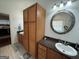 Dual sink bathroom with wood cabinets, granite counters, and tile floors at 180 Cooper Rd, Social Circle, GA 30025