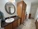 Bathroom with a single vanity, granite countertops, tiled floors and dark wood cabinets at 180 Cooper Rd, Social Circle, GA 30025