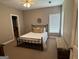 Bedroom boasts a plush bed, carpet, and bench with natural light from two windows at 180 Cooper Rd, Social Circle, GA 30025
