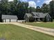 Beautiful home with a long driveway, lush lawn and separate two-car garage at 180 Cooper Rd, Social Circle, GA 30025