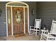 Charming front entrance with a decorative wood door, rocking chairs, and a welcoming 'hello' mat at 180 Cooper Rd, Social Circle, GA 30025