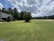 Expansive front yard with mature trees and lush grass, creating a serene and private setting at 180 Cooper Rd, Social Circle, GA 30025