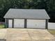 Detached two-car garage with white doors and siding complements the home's exterior at 180 Cooper Rd, Social Circle, GA 30025
