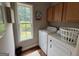 Bright laundry room with wood cabinets and a window providing natural light at 180 Cooper Rd, Social Circle, GA 30025