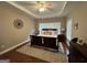 Spacious bedroom with trey ceiling, fan, dark furniture, hardwood floors and an oversized rug at 180 Cooper Rd, Social Circle, GA 30025