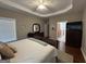 Bright bedroom with trey ceiling, fan, dark furniture, hardwood floors and a view of the bathroom at 180 Cooper Rd, Social Circle, GA 30025