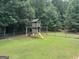 Backyard featuring a wooden playset with swings, slide and a look-out tower at 180 Cooper Rd, Social Circle, GA 30025