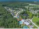 Aerial view of residential community, pond, pool, tennis court, and wooded area at 301 Retreat Way, Carrollton, GA 30116