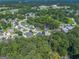 Aerial view of residential community, pond, pool, tennis court, and wooded areas at 301 Retreat Way, Carrollton, GA 30116