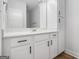 Bright bathroom featuring white cabinets, black hardware, a large mirror, and a white countertop at 301 Retreat Way, Carrollton, GA 30116