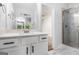 Bright bathroom featuring white cabinets, marbled tile floors, and a glass-enclosed shower at 301 Retreat Way, Carrollton, GA 30116