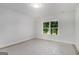 Bright bedroom with a large window and a view of trees; light walls and flooring at 301 Retreat Way, Carrollton, GA 30116