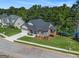 Lakefront Craftsman-style home boasts a manicured lawn, attached garage, and covered deck overlooking the water at 301 Retreat Way, Carrollton, GA 30116