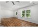 Living room with hardwood floors, a ceiling fan, and a large window overlooking trees at 301 Retreat Way, Carrollton, GA 30116