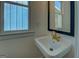 Charming bathroom with a classic sink, gold faucet, and a black-framed mirror, complemented by natural light at 5106 N Pratt St, Covington, GA 30014