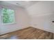 Bright bedroom with wood-look floors and large window with a view of lush trees at 5106 N Pratt St, Covington, GA 30014