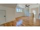 Spacious bedroom featuring hardwood floors, a ceiling fan, and a well-lit view of the staircase at 5106 N Pratt St, Covington, GA 30014