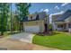 View of the exterior of the garage with stairs, green grass and trees at 5106 N Pratt St, Covington, GA 30014