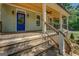 Spacious covered porch with wood ceiling and stylish blue front door at 5106 N Pratt St, Covington, GA 30014
