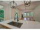 Modern kitchen with a spacious island, stainless steel sink, and view into the living area at 5106 N Pratt St, Covington, GA 30014