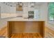Bright kitchen features white cabinets, wood floors, modern appliances and a large kitchen island at 5106 N Pratt St, Covington, GA 30014